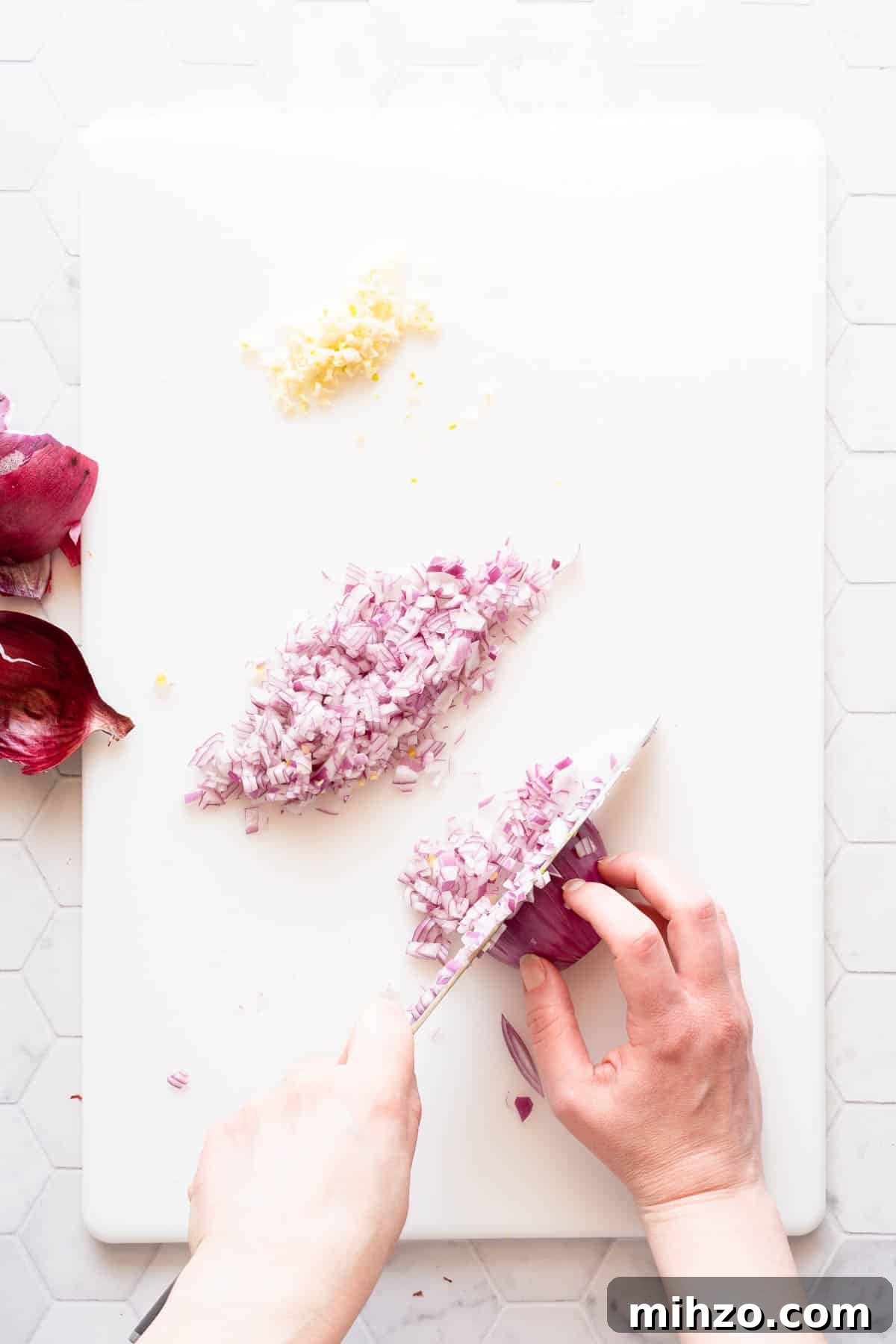 red onion being finely chopped on cutting board.