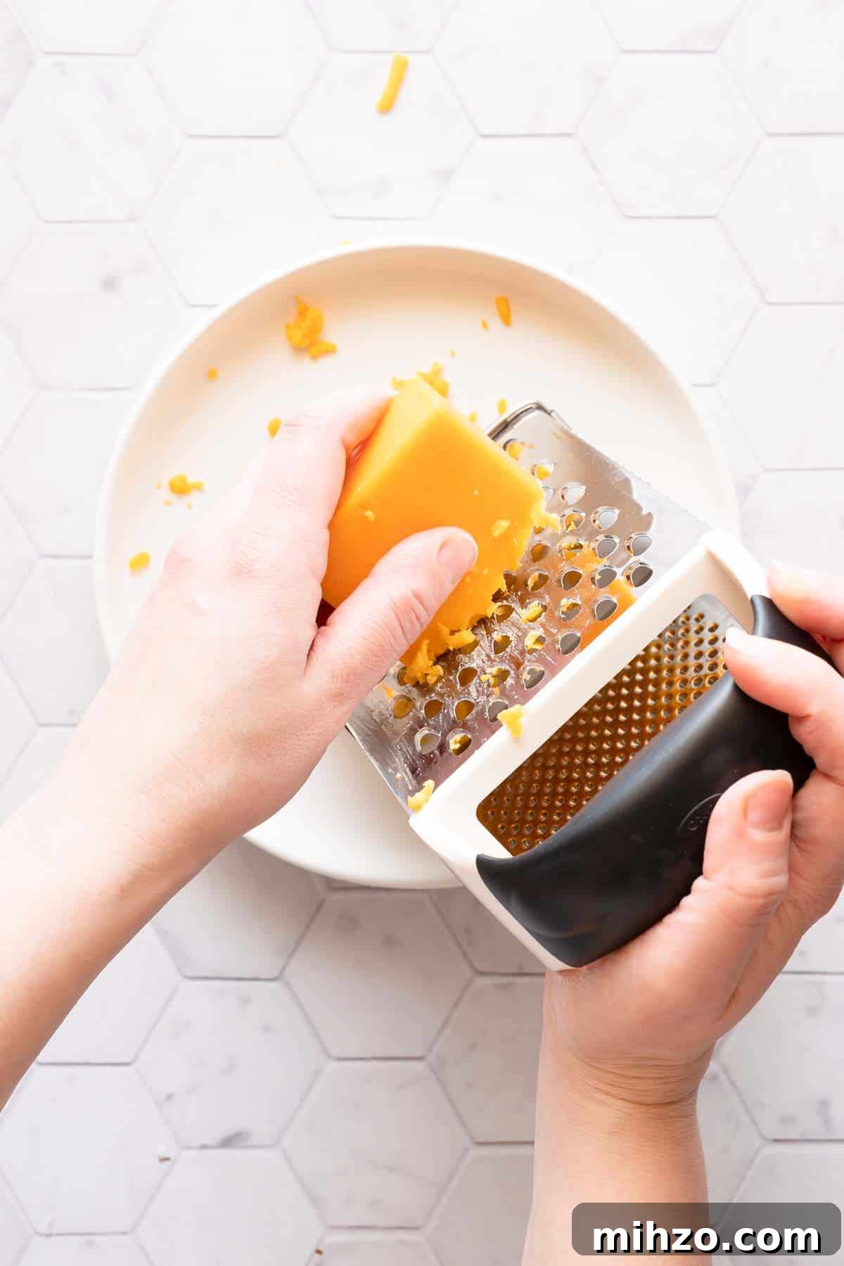 cheese being shredded with box grater.