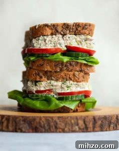 Tuna Sandwich 2 sandwiches stacked on each other on wooden board