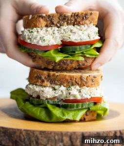 Tuna Salad Sandwich holding sandwich above another sandwich showing filling