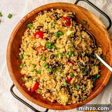 Quinoa salad in a wooden bowl with tomatoes.
