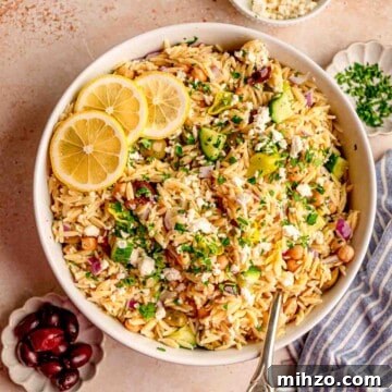 A bowl of lemon orzo salad topped with lemon slices.