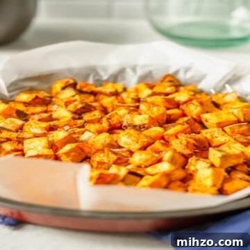 air fried sweet potato cubes in a basket on a blue cloth
