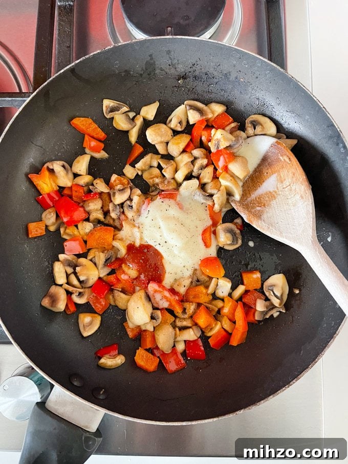 Cheesy Veggie Quesadillas with Roasted Peppers and Spinach 6 Cheese spread and chilli sauce being added to the cooked peppers and mushrooms.