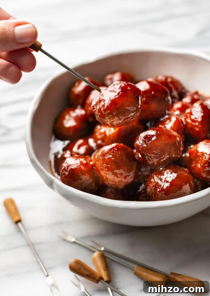 Sweet and Tangy Grape Jelly Meatballs 5 grape jelly meatballs in a white bowl