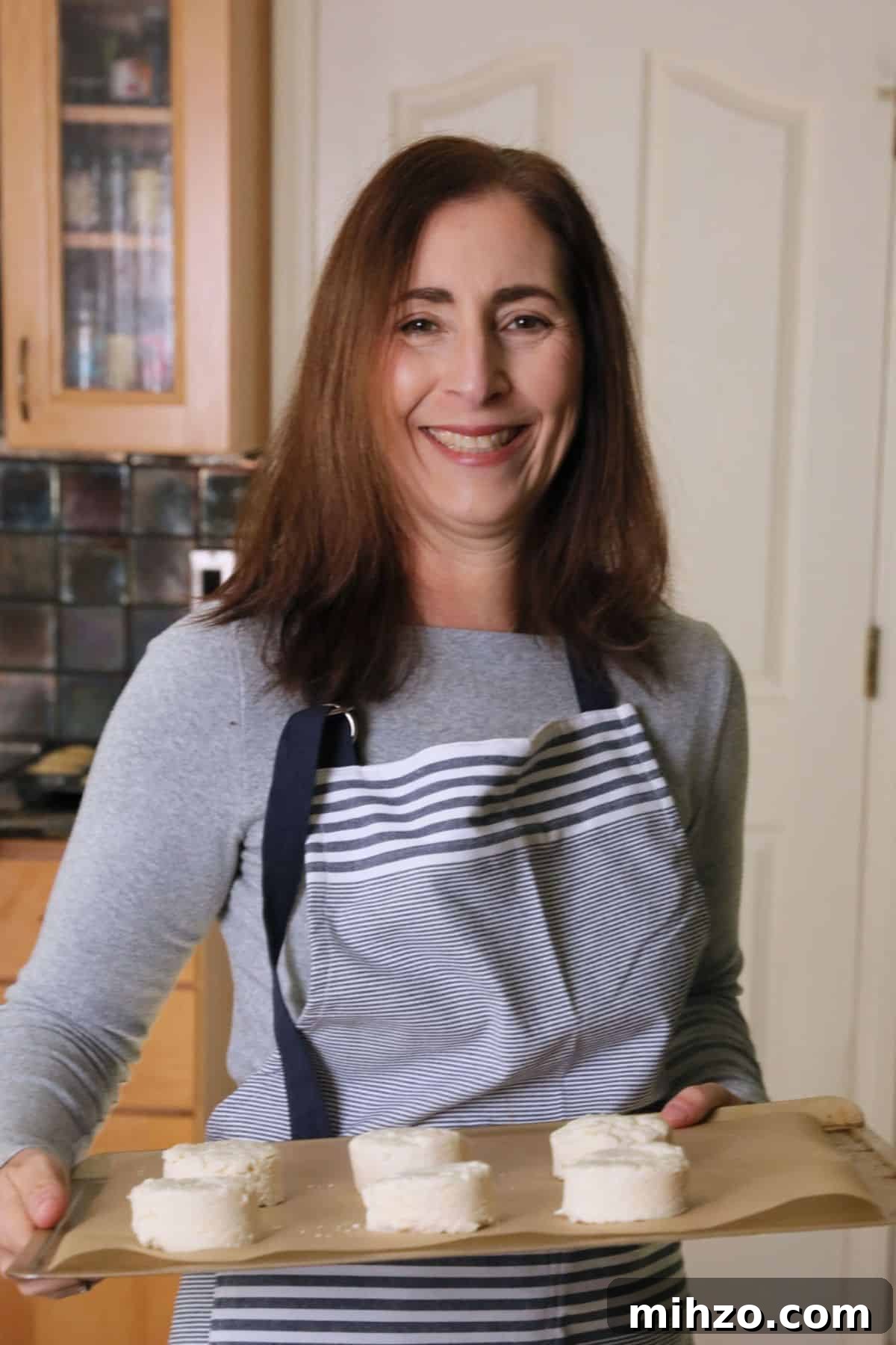 Gluten-Free Cranberry Pound Cake with Dairy-Free Option 3 Sandi holding a tray of biscuits that are going in the oven to bake.