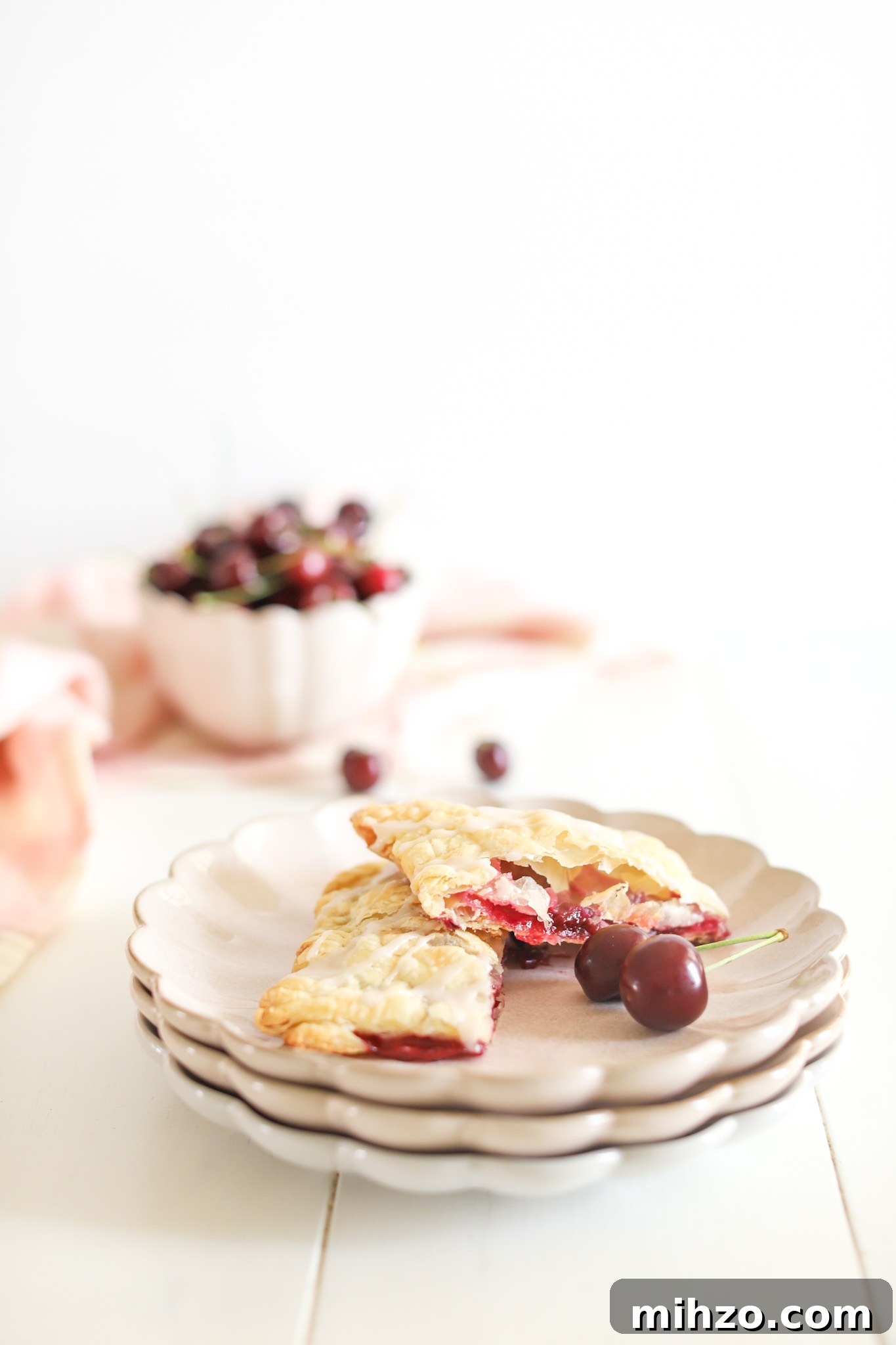 Cherry Pop Tarts cut in half on plate with fresh cherries