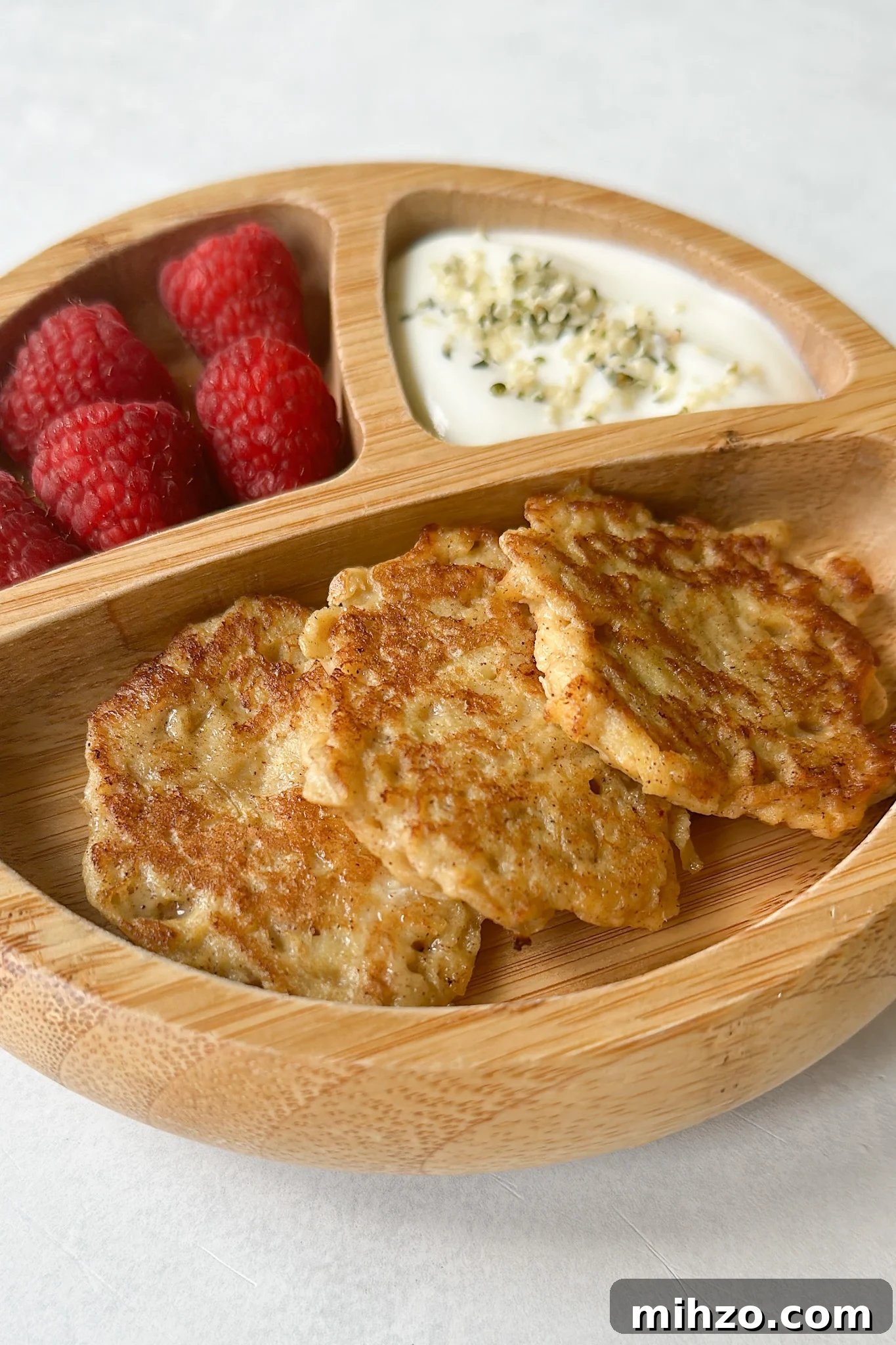 Cinnamon apple fritters served with raspberries and yogurt.