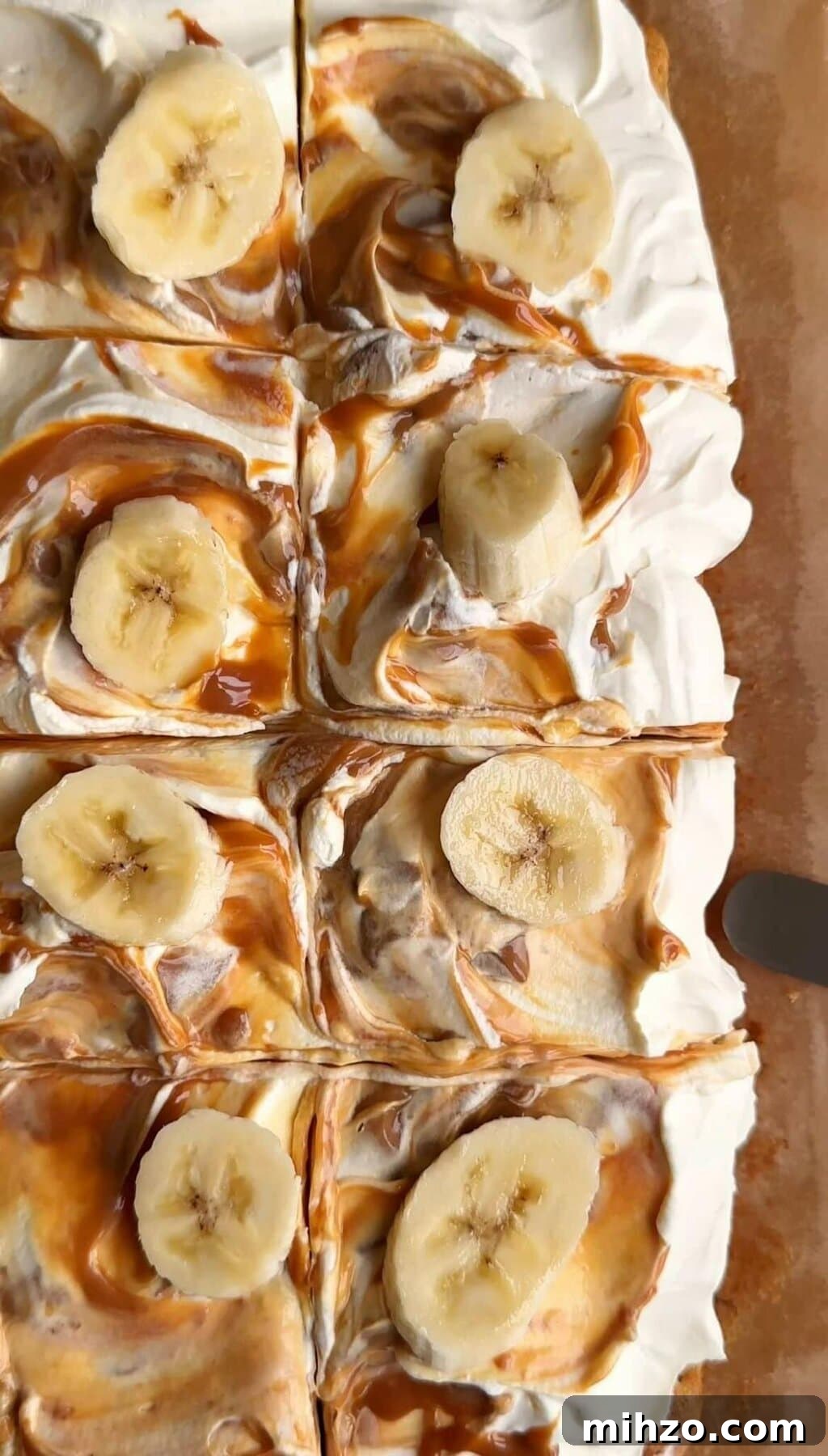 sliced squares of banana bread bars with swirled caramel icing on top and banana slices