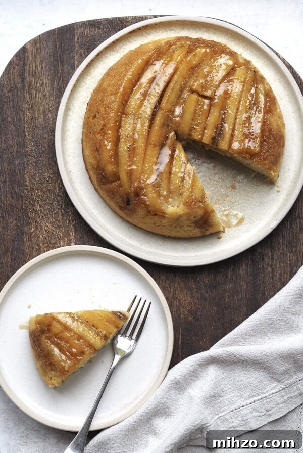 upside down banana cake on a white plate with a slice out
